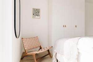 a bedroom with a chair next to a bed at Ferienwohnung Nordic Calm am Kellersee in Malente