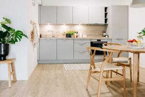 a kitchen with white cabinets and a table and chairs at Ferienwohnung Nordic Calm am Kellersee in Malente