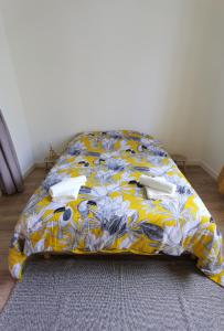 a bed with a yellow and blue comforter at Quatre Moulins - 3 chambres - WIFI - Refait à neuf in Brest