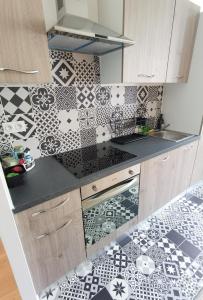 a kitchen with black and white tiles on the wall at Quatre Moulins - 3 chambres - WIFI - Refait à neuf in Brest