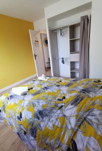 a bedroom with a bed with a yellow and blue blanket at Quatre Moulins - 3 chambres - WIFI - Refait à neuf in Brest