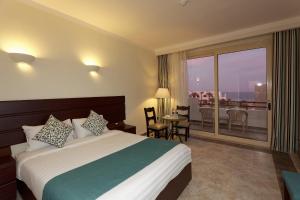 A bed or beds in a room at Three Corners Equinox Beach Resort