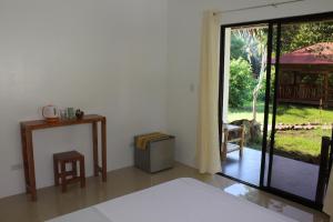 una sala de estar con una puerta que da a un patio en Happy Coconut Camiguin en Mambajao