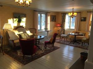 - un salon avec un canapé, une table et des chaises dans l'établissement Handlarens villa - Vandrarhem de luxe, à Söderbärke