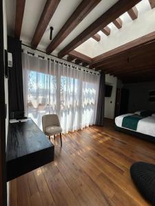 a bedroom with a bed and a large window at Hotel Boutique Rayón 50 in Morelia