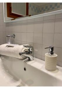 lavabo con grifo y toalla en civico 38, en Bassano del Grappa