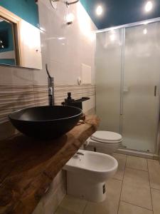 a bathroom with a black sink and a toilet at Al Civico 15 Apartment in Salerno