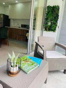 een tafel met een plant in een mand erop bij Apartamento en Granada con piscina, turco, estacionamiento in Cali