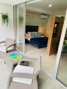 una sala de estar con una cama y una habitación con sillas en Apartamento en Granada con piscina, turco, estacionamiento, en Cali