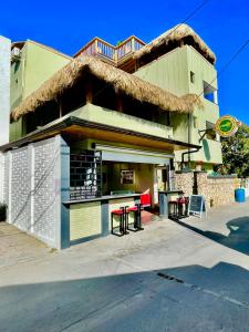 um edifício com telhado de palha, mesa e cadeiras em Villa Iguana em Bayahibe