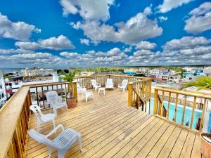 a deck with white chairs and a view of the water at Villa Iguana in Bayahibe