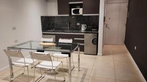 a kitchen with a glass table and white chairs at Dessau VI in San Luis
