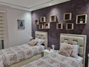 two beds sitting next to each other in a bedroom at Vue panoramique sur la baie de Tanger in Tangier