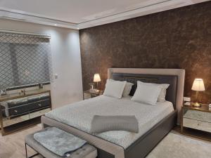 um quarto com uma cama grande e duas mesas de cabeceira em Vue panoramique sur la baie de Tanger em Tânger
