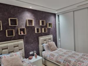 a bedroom with a bed and mirrors on the wall at Vue panoramique sur la baie de Tanger in Tangier