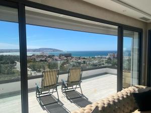 two chairs sitting on the balcony of a house at Vue panoramique sur la baie de Tanger in Tangier