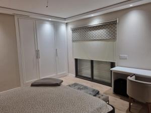 a bedroom with a bed and a desk and a window at Vue panoramique sur la baie de Tanger in Tangier