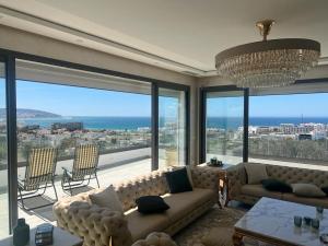 a living room with a couch and a large window at Vue panoramique sur la baie de Tanger in Tangier