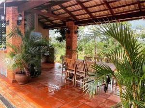 un patio con mesa, sillas y plantas en Magia da Serra Casa Temporada en Pirenópolis