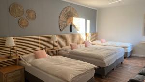 1 dormitorio con 2 camas y ventilador en la pared en Zimmer AsiaDreieck Pension en Lauterecken