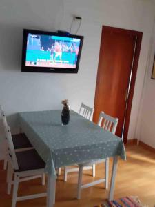 a table and chairs with a television on the wall at Pisito bonito y funcional en Pineda De Mar in Pineda de Mar