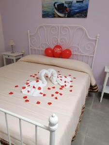 un letto con cuori rossi su una coperta bianca di B&B Petra Hercules a Torre Annunziata
