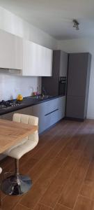 a kitchen with a wooden table and white cabinets at Spilamberto 6b - 12mins from San Donato M3 station in San Donato Milanese
