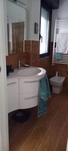 a bathroom with a white sink and a toilet at Spilamberto 6b - 12mins from San Donato M3 station in San Donato Milanese