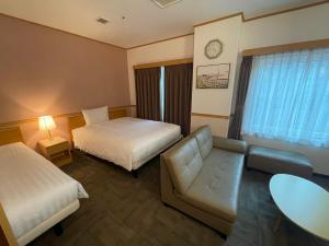 a hotel room with two beds and a couch at Toyoko Inn Busan Seomyeon in Busan