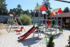 einen Spielplatz mit Rutsche im Sand in der Unterkunft Oaza in Turawa