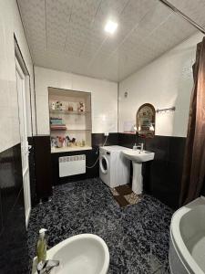 a black and white bathroom with a sink and a toilet at Guest House Melissa in Duisi