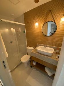a bathroom with a sink and a toilet and a mirror at Quarto para 4 pessoas in Campos dos Goytacazes