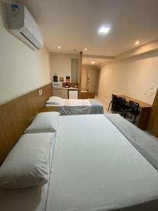 a hotel room with three beds and a desk at Quarto para 4 pessoas in Campos dos Goytacazes