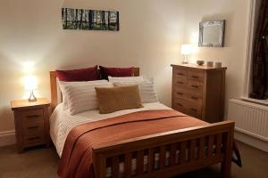 a bedroom with a bed with two night stands and two lamps at Pavilion View in Buxton