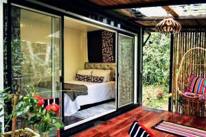 a screened in porch with a bed on a patio at Casa de Piedra in Mindo