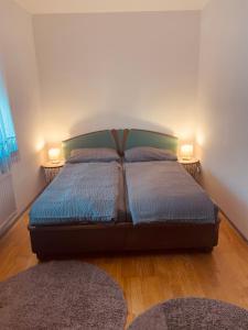 a bed in a room with two lamps on two tables at RELAX APPARTEMENT - Graz in Graz