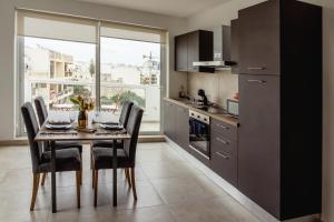 a kitchen with a table and chairs and a table and a window at Stunning 1BDR Sliema-Center Penthouse! Near POOL! in Sliema