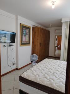 1 dormitorio con 1 cama y TV de pantalla plana en Guarapari - Apto Linda Vista 2 - Beira Mar-Praia do Morro, en Guarapari