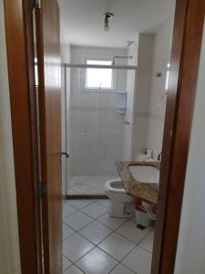 y baño con ducha, aseo y lavamanos. en Guarapari - Apto Linda Vista 2 - Beira Mar-Praia do Morro, en Guarapari