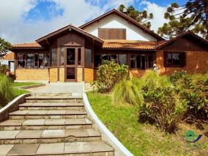 a house with a pathway leading to the front door at Morada Das Araucárias in São Francisco de Paula