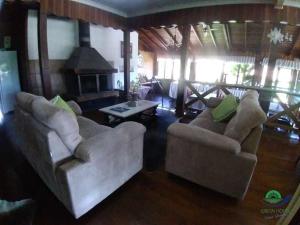 a living room with two chairs and a fireplace at Morada Das Araucárias in São Francisco de Paula