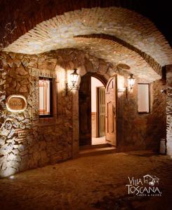 una entrada a un edificio de piedra con puerta en Villa Toscana ValQuirico Lofts & Suites Hotel Boutique, en Santeagueda