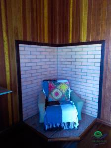 a miniature chair with a pillow in a mirror at Morada Das Araucárias in São Francisco de Paula