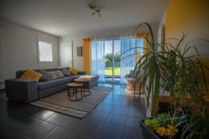 ein Wohnzimmer mit einem Sofa und einem Tisch in der Unterkunft Maison à 800m de la plage in Saint-Lunaire