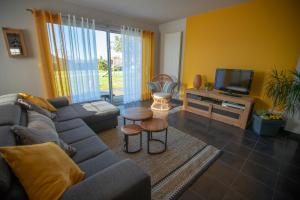 a living room with a couch and a tv at Maison à 800m de la plage in Saint-Lunaire