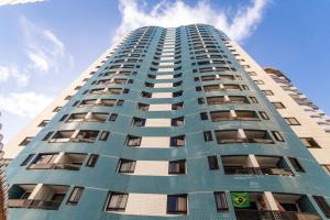 um edifício de apartamentos alto e azul com o céu ao fundo em Conde da Praia #501 Conforto em Natal by Carpediem em Natal