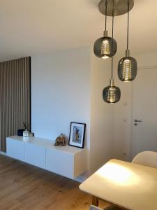 a living room with a white table and lights at Modernes Apartment in zentraler Lage in Chemnitz