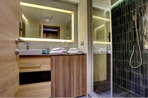 科帕奥尼克Tramontana Kopaonik Woodside 201, FREE Parking & SPA的带水槽和带镜子的淋浴的浴室