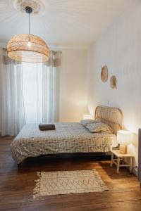 a bedroom with a bed and a large window at Appart chaleureux face gare in Limoges