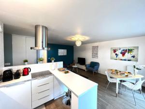 a kitchen with a white counter and a dining room at Paris La-Defense - U Arena - 2 Bedrooms - Parking, Terrace & Wifi in Nanterre